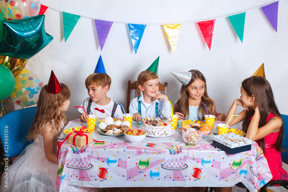 Group of joyful little kids celebrating birthday party at home. Children's funny  birthday party in decorated room Stock Photo | Adobe Stock