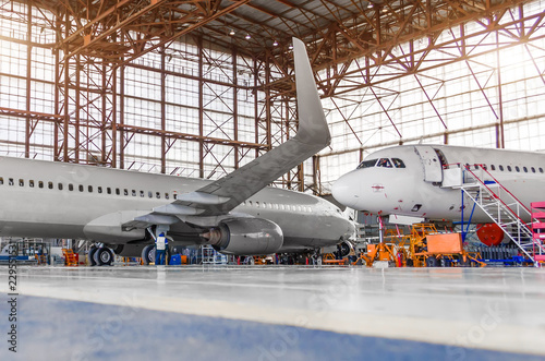 Two passenger aircraft for maintenance and repair in the hangar.