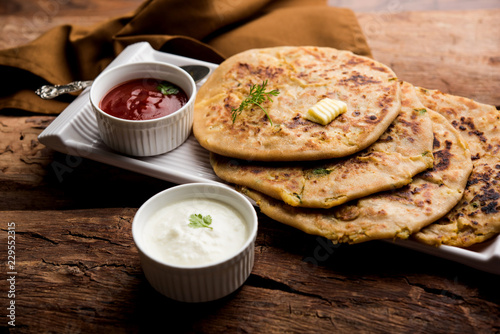 Aloo Paratha / Indian Potato stuffed Flatbread. Served with fresh curd and tomato ketchup. selective focus