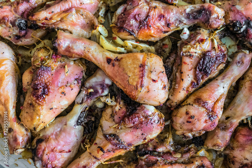 Chicken legs baked with onions. Cooked chicken meat.