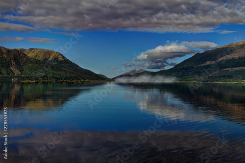 Fototapeta Naklejka Na Ścianę i Meble -  View over a lake with mountains at the blue hour