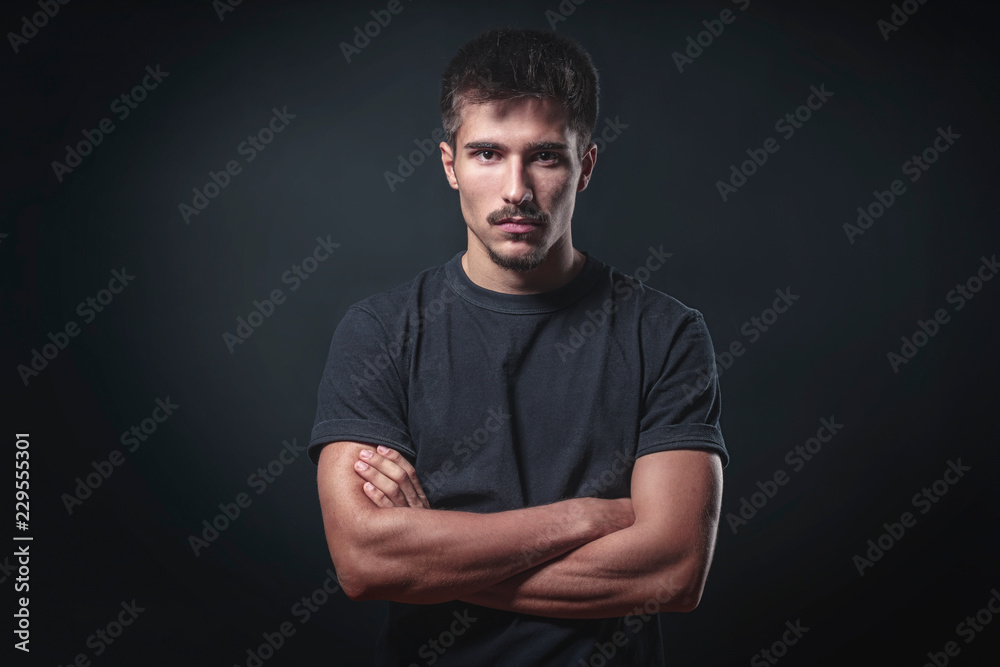 portrait of a strong young man with black background