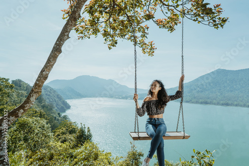 asian woman portrait on a swing with beautiful nature background