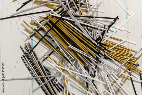 Table full of plastic straws in gold, silver, white and black