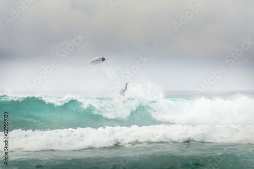Surfer falling off wave