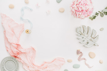 Round frame with mockup space for text of hydrangea flower bouquet, eucalyptus branch, pastel pink blanket, monstera leaf plate on white background. Flat lay, top view.