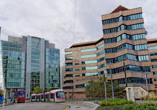 Modern metro wagons and red bus on the Birmingham's business district, UK