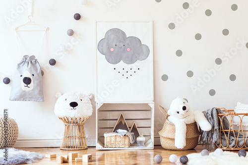 Stylish scandinavian child room with mock up photo poster frame on the pattern wall, boxes, teddy bear and toys.Cute modern interior of playroom with white walls, wooden accessories and colorful toys. photo