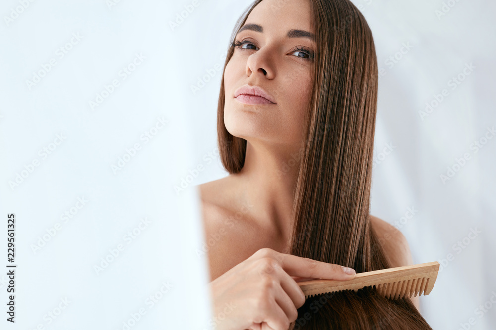 Naklejka premium Pielęgnacja włosów uroda. Piękna kobieta czesanie długie naturalne włosy