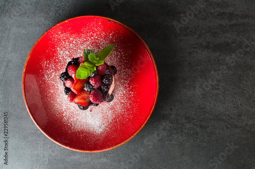 Dessert with berries on a red plate