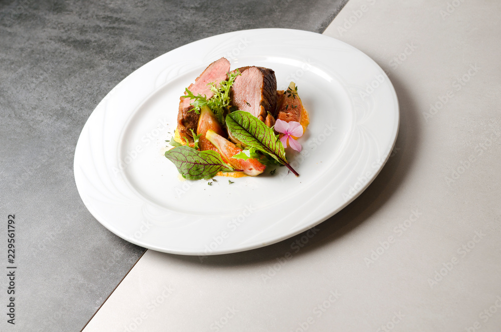 Duck fillet with figs and carrot puree on a white plate Duck fillet with figs and carrot puree on a white plate