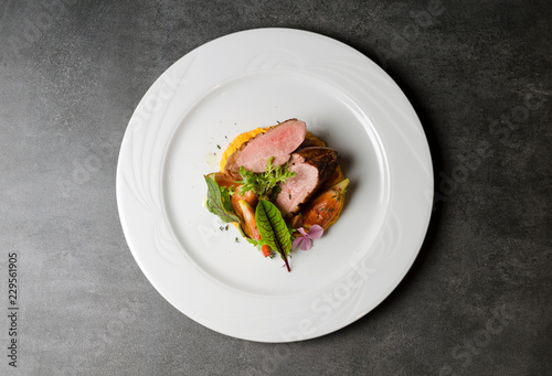 Duck fillet with figs and carrot puree on a white plate