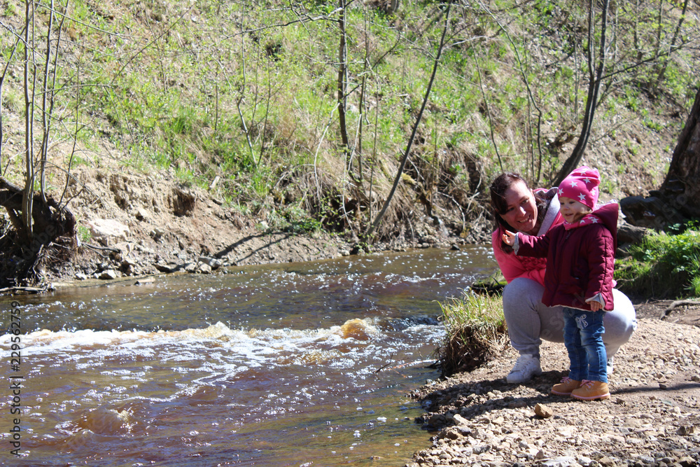 Walk daughter with her mother on the nature near the water. Walk daughter with her mother on the nature near the water.