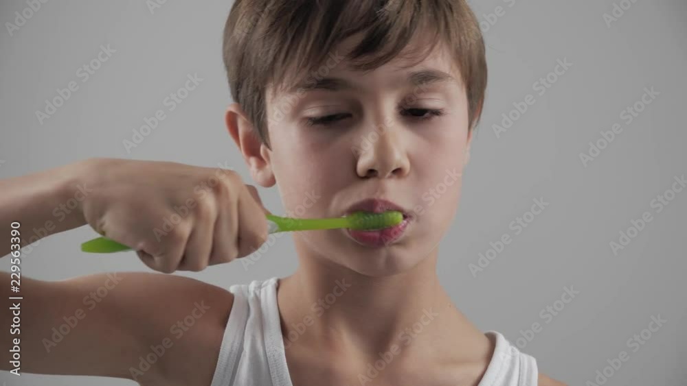 Lttle boy brushing his teeth in bathroom and stop becuse of a tooth pain. Dental problems Lttle boy brushing his teeth in bathroom and stop becuse of a tooth pain. Dental problems