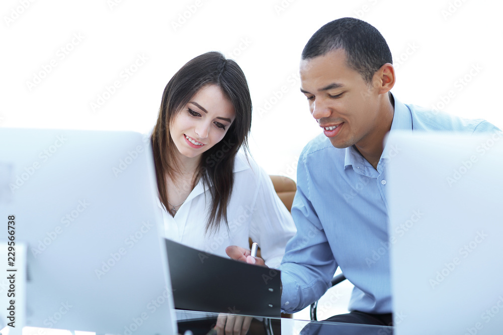 employees discussing financial documents sitting at a Desk employees discussing financial documents sitting at a Desk