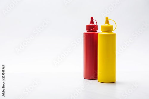 close-up shot of bottles of ketchup and mustard on white surface