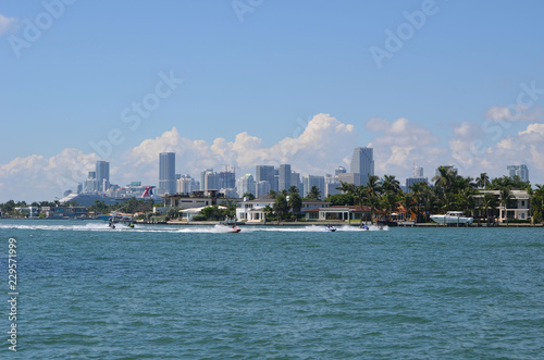 View looking west from a vantage point in Miami Beach of jet skiers on the Florida Intra-Coastal Waterway,expensive island home on Rivo Alto in Miami Beach and the Miami skyline. photo