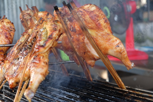 Grilled whole chicken on the flaming grill. Grilled whole chicken marinated in honey and soy sauce.
