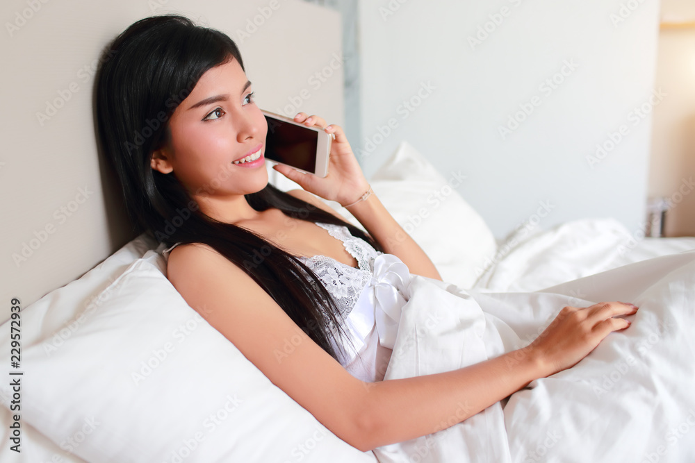 young and sexy woman using cell phone on bed young and sexy woman using cell phone on bed