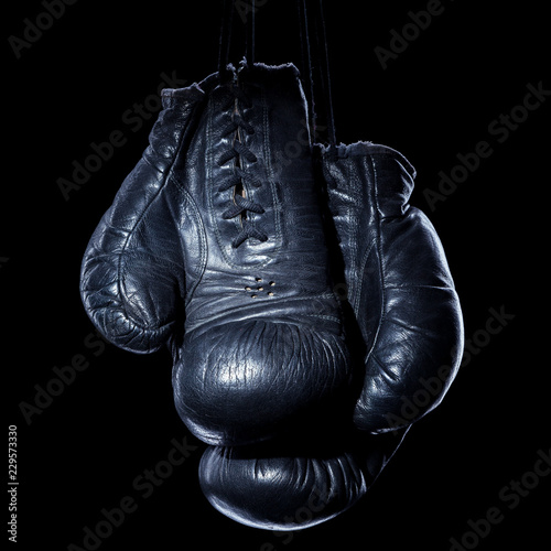Old boxing gloves on an isolated black background © BortN66