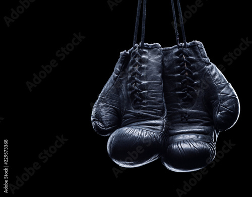 Old boxing gloves on an isolated black background © BortN66