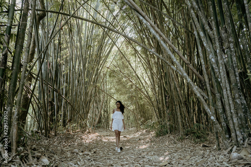 Fototapeta Naklejka Na Ścianę i Meble -  stylish young woman taking picture for social media in bamboo fo