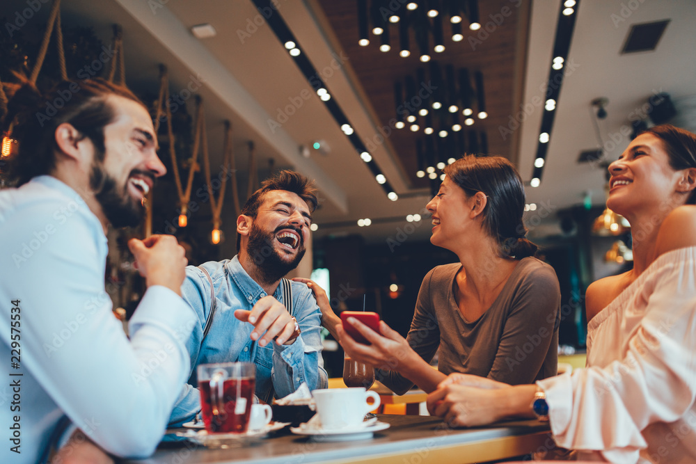 Group of Happy friends having with smartphone in cafe