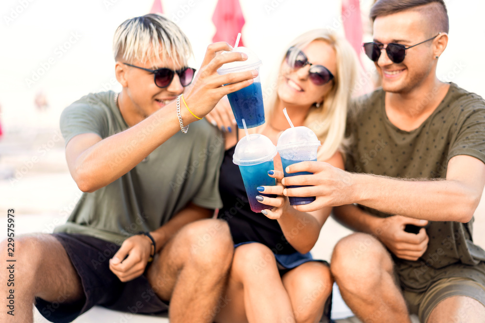 three friends on the beach drinking cocktails fun three friends on the beach drinking cocktails fun