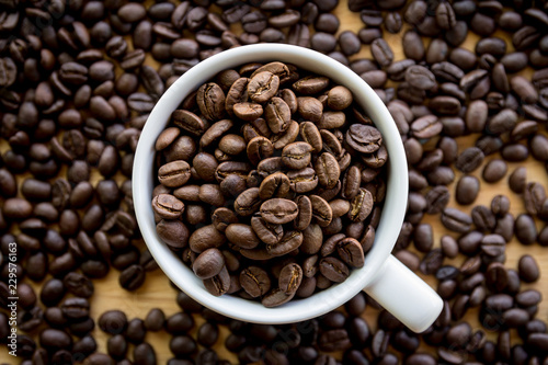 Close up of white coffee cup full of coffee beans background with copy space
