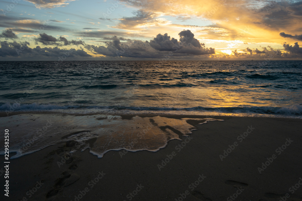 Beautiful sunset at the beach. Cloudy day witn a lot of reflections on the water Beautiful sunset at the beach. Cloudy day witn a lot of reflections on the water