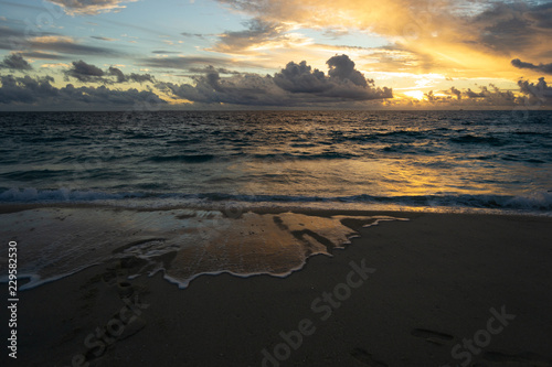 Beautiful sunset at the beach. Cloudy day witn a lot of reflections on the water