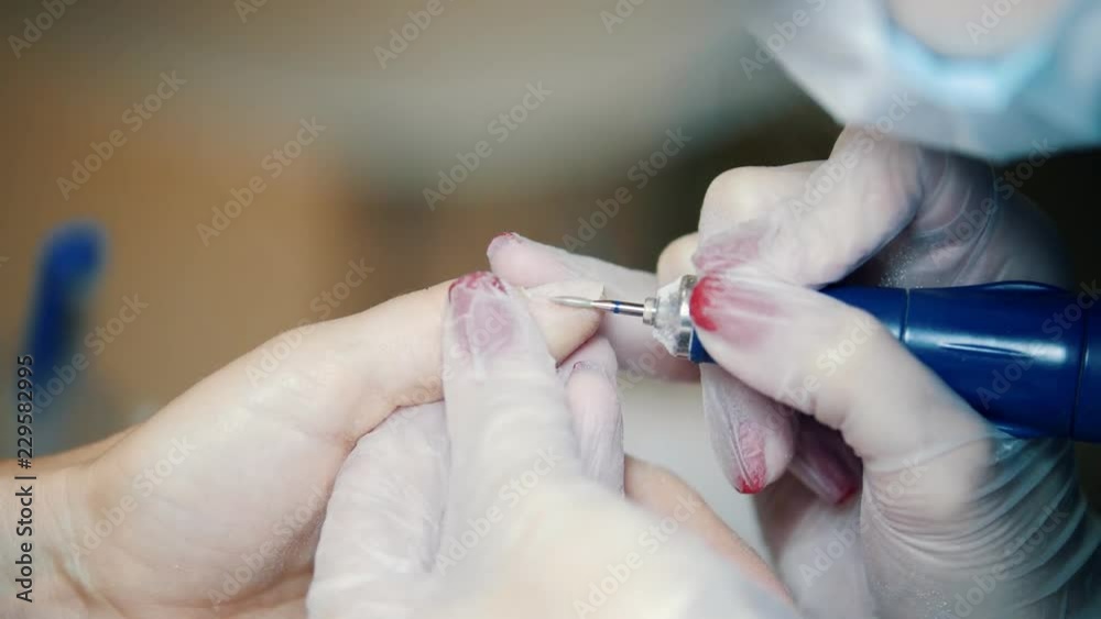 Hardware manicure in a cosmetology clinic. Working with a electric remover