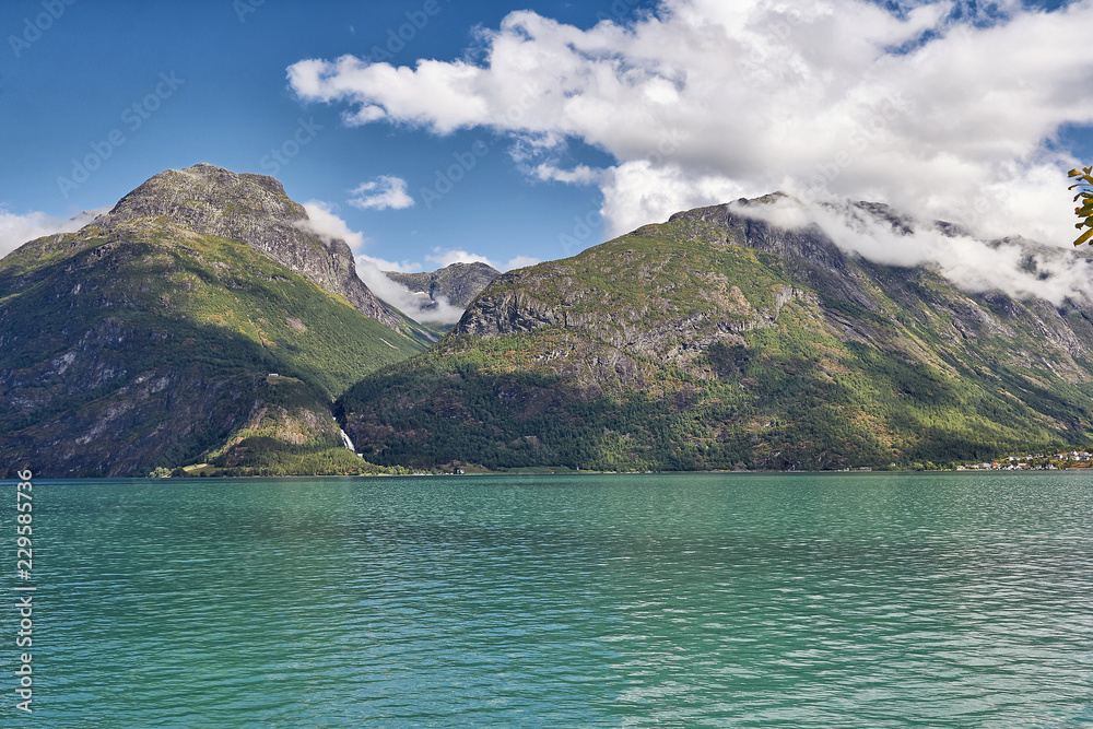traumhafter Fjord mit blauem Himmel und Wolken im Gebirge