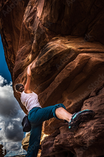 Photography Girl Climber practicing bouldering on a beautiful red rock in Canyonlands Utah U