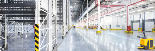 Empty huge distribution warehouse with high shelves and pallets