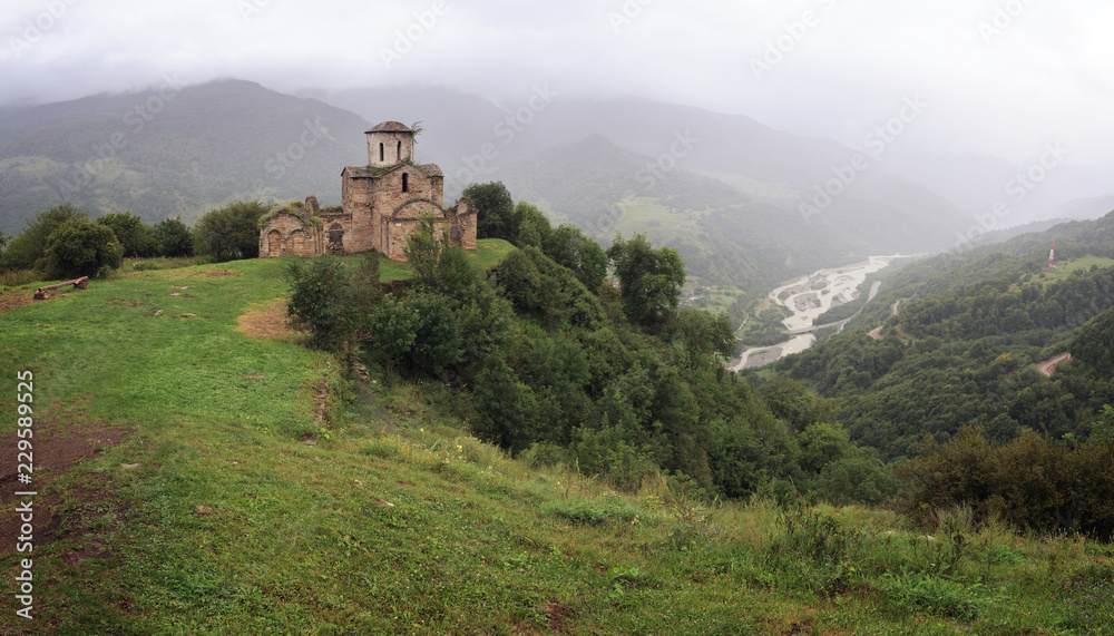 Panoramic view of an ancient monastery on top of a mountain in the Caucasus in Russia.