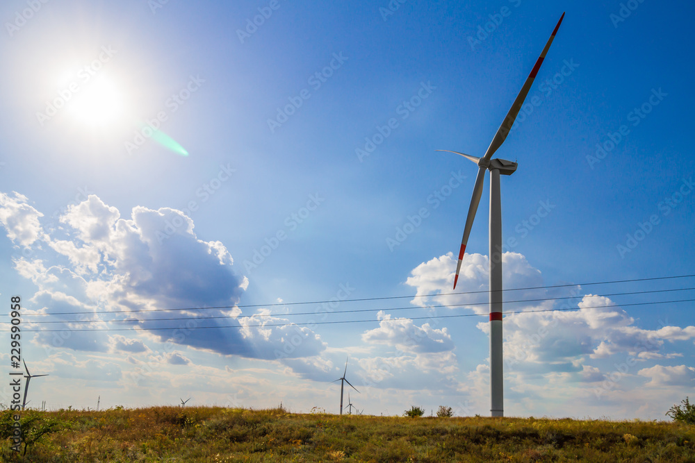 Windmill for electric power production on blue sky background.