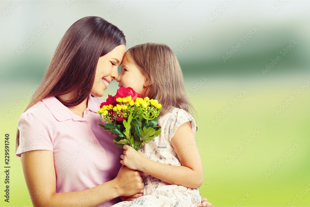 Portrait of happy mother and daughter holding flowers Portrait of happy mother and daughter holding flowers