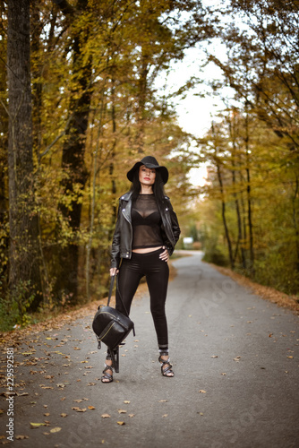 Young woman posing a an autumn day on a road in the woods. © xpabli