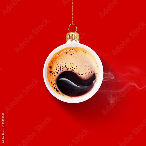 Christmas toy is made from a fragrant cup of coffee. Christmas toy. Holiday concept. Fragrant coffee on a red background for your advertising. Smoke from hot coffee.