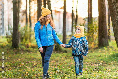 mom and son in yellow hats walking in the woods