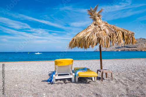 Empty sunbeds and umbrella on Vlycha beach near Lindos village  Rhodes  Greece 