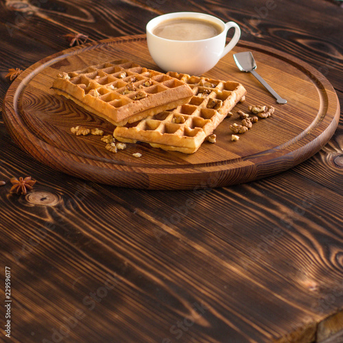 fresh belgian waffles, tasty jam and latte coffee on a wooden background. top view.