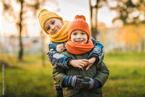 two boys in  hats hug each other