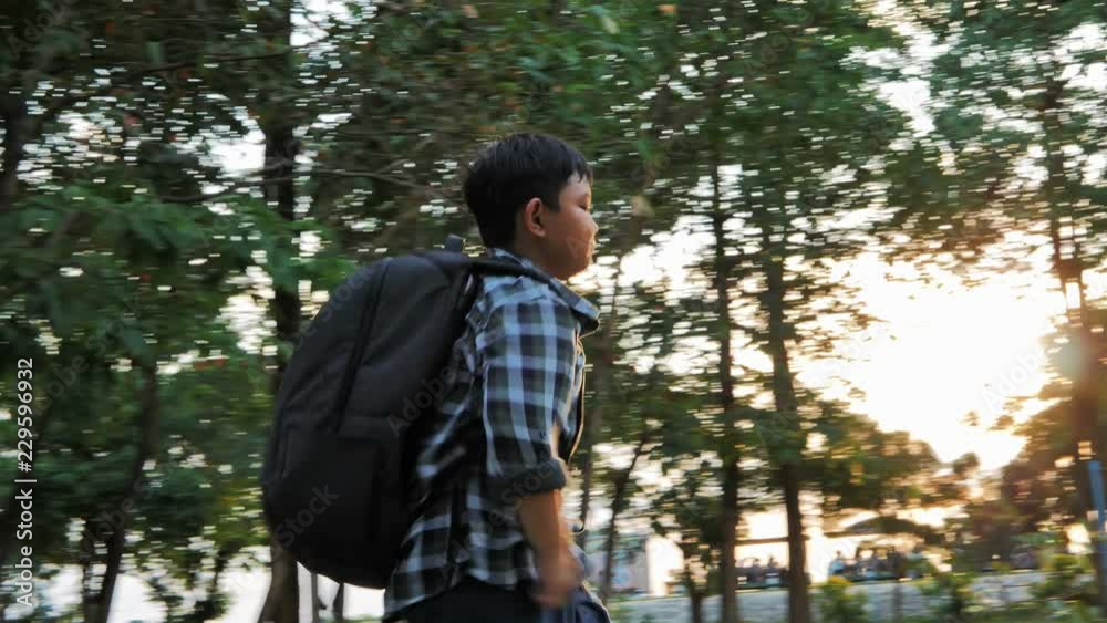 Asian children with backpack are walking and sunlight in the park. Asian children with backpack are walking and sunlight in the park.