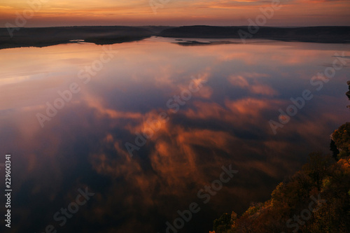 Scenic sky reflection in the water. Beautiful colorful sunset over the lake. Dusk. © WellStock