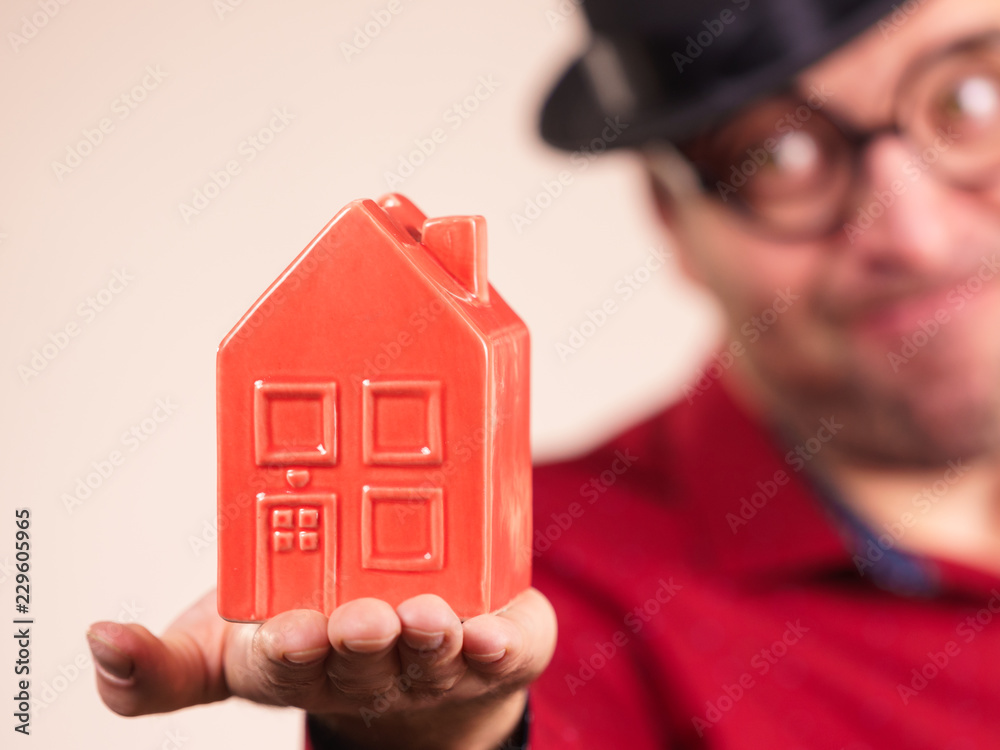 Man wearing funny eyeglasses holding house Man wearing funny eyeglasses holding house