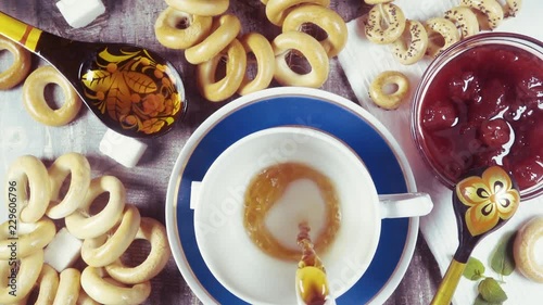 Slow motion traditional Russian tea-party with crackers Sushki and jam top view photo