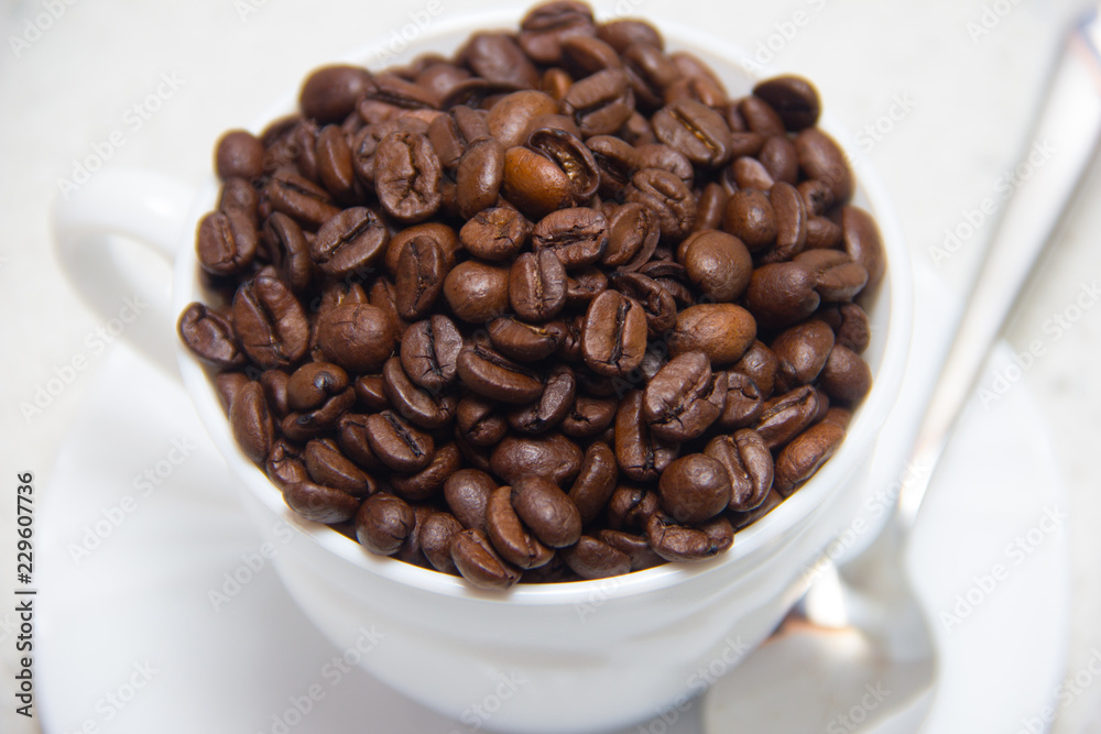 Coffee beans in a white Cup. Preparation of coffee. Close up Coffee beans in a white Cup. Preparation of coffee. Close up