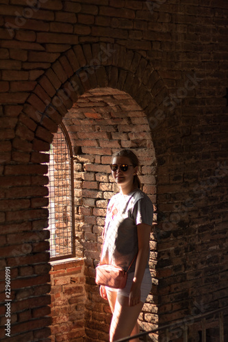 young woman in front of brick wall